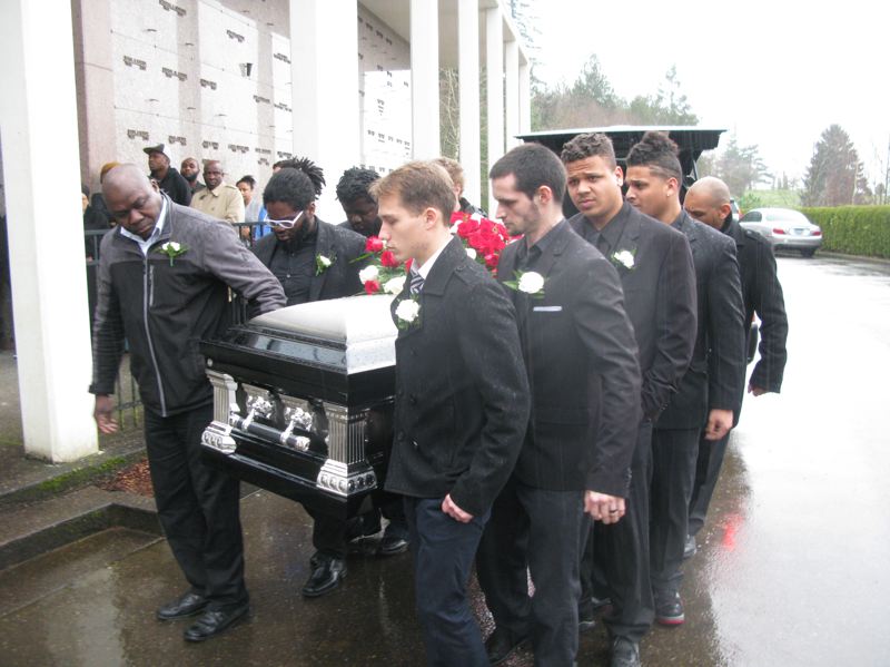 Kalonji's casket is carried from the hearse to the funeral site